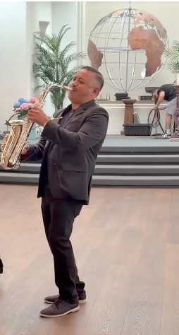 Portrait of NecxtoSax performing on saxophone indoors